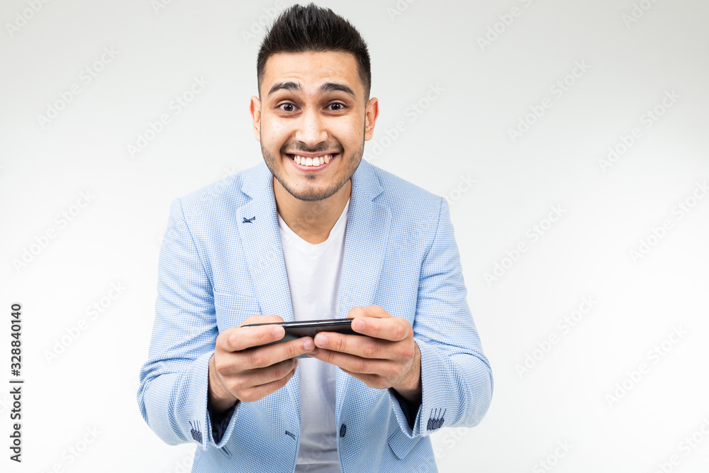 portrait of a brunet businessman in a stylish jacket watching video on a smartphone on a white background portrait of a brunet businessman in a stylish jacket watching video on a smartphone on a white background