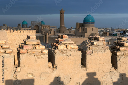 Sunset view from Ark fortress (in focus) at Great Minaret of the Kalon (out of focus), Kalon (Kallan) Mosque and Mir-i-Arab Madrasa. Bukhara, Uzbekistan, Central Asia. photo