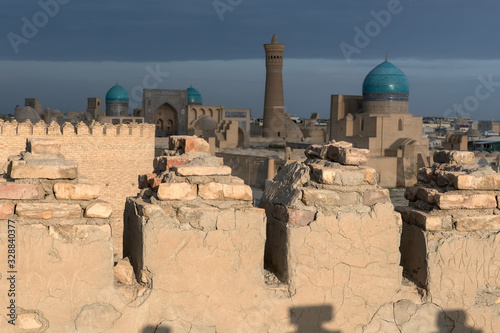 Sunset view from Ark fortress (in focus) at Great Minaret of the Kalon (out of focus), Kalon (Kallan) Mosque and Mir-i-Arab Madrasa. Bukhara, Uzbekistan, Central Asia.