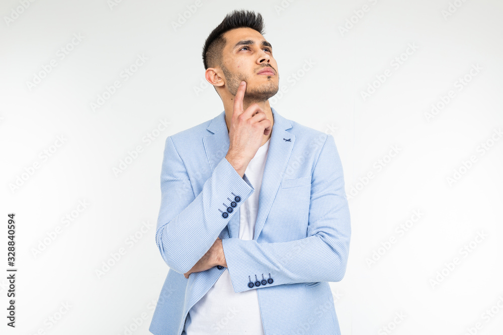 charming man in a blue classic jacket thinks of a solution and a problem on a white background with copy space charming man in a blue classic jacket thinks of a solution and a problem on a white background with copy space