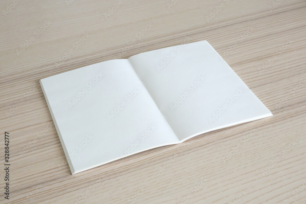 Mock up blank open paper book on wood table background Mock up blank open paper book on wood table background