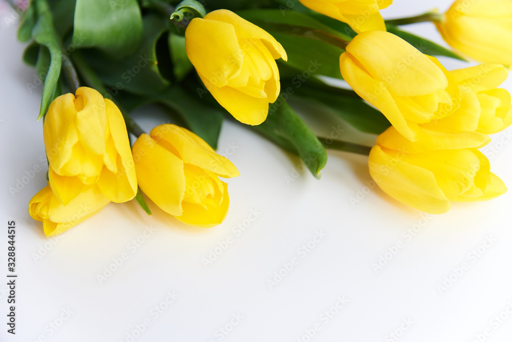Yellow tulips lie on a white table Yellow tulips lie on a white table