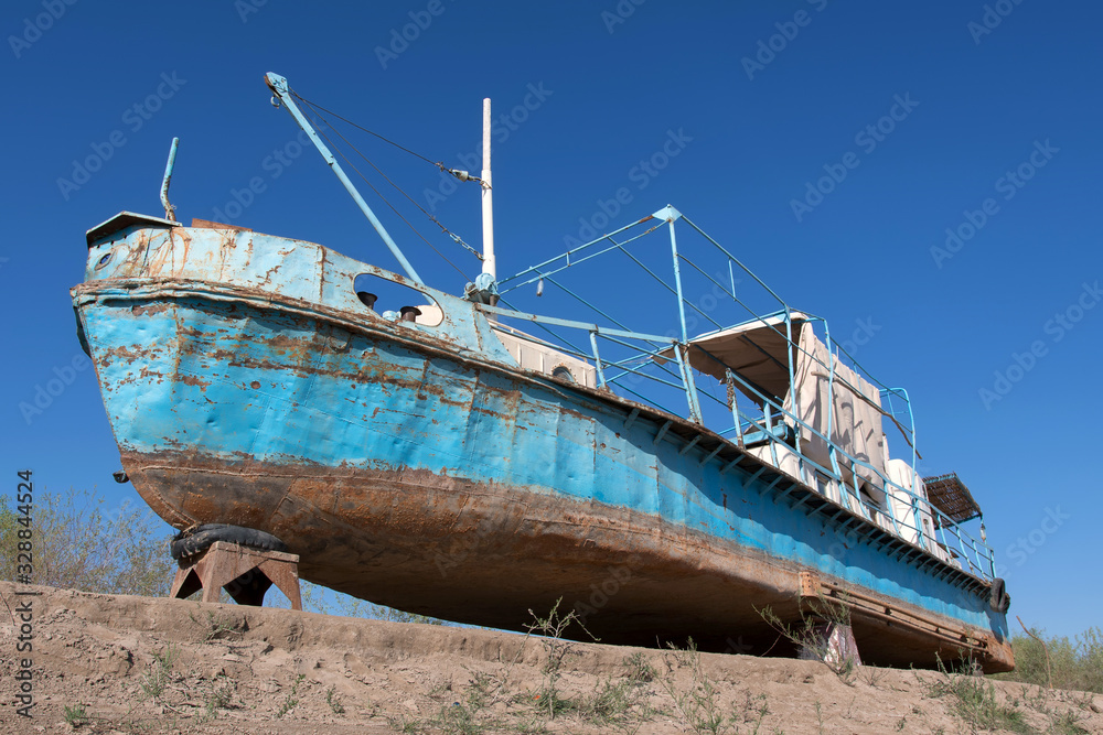 Old rusty boat on the bank of Amu Darya River. Uzbekistan, Central Asia.