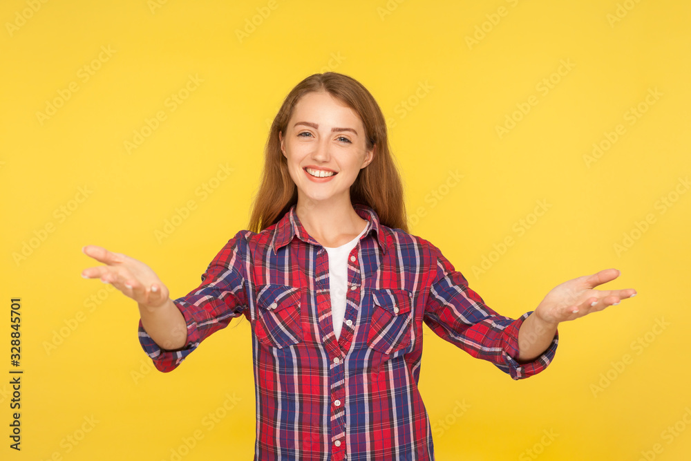 Please, take it. Portrait of kind generous ginger girl in casual shirt standing with wide open hands as if sharing for free, giving charity and smiling. studio shoot isolated on yellow background Please, take it. Portrait of kind generous ginger girl in casual shirt standing with wide open hands as if sharing for free, giving charity and smiling. studio shoot isolated on yellow background