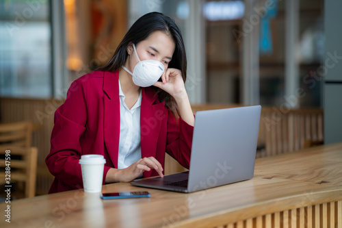 Asian girl use a protection mask for prevent PM 2.5 and corona viruus or covic 19 in office photo