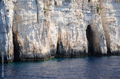 Blue caves on the shore of Paxos Island seen from the sea photo