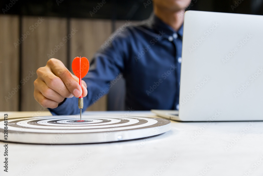Businessman holding a darts aiming at the target center,business growth success concept. Businessman holding a darts aiming at the target center,business growth success concept.