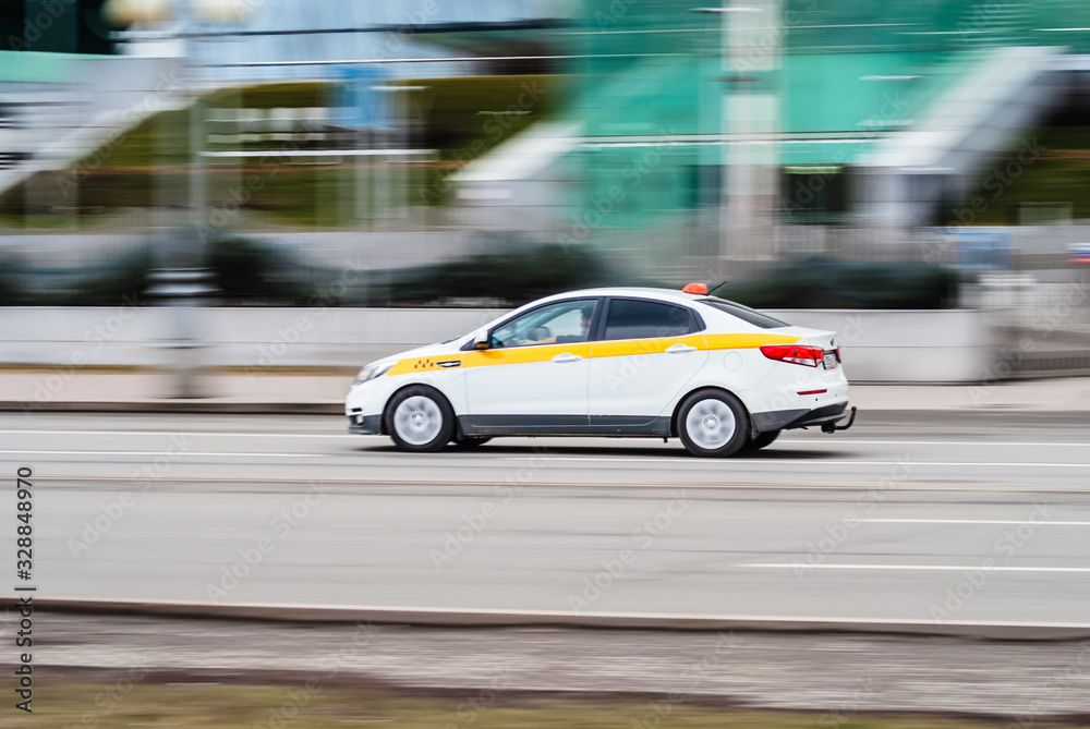 Motion city street scene with white taxi vehicle. Fast moving white taxi car on Moscow streets Motion city street scene with white taxi vehicle. Fast moving white taxi car on Moscow streets