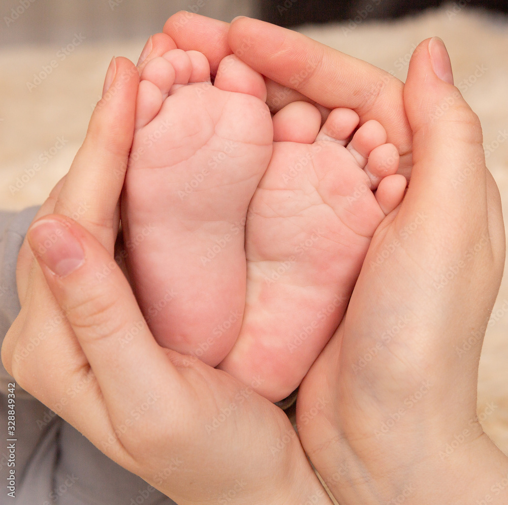 Baby feet in mother hands. Tiny Newborn Baby's feet on female Shaped hands closeup. Mom and her Child. Happy Family concept. Beautiful conceptual image of Maternity Baby feet in mother hands. Tiny Newborn Baby's feet on female Shaped hands closeup. Mom and her Child. Happy Family concept. Beautiful conceptual image of Maternity