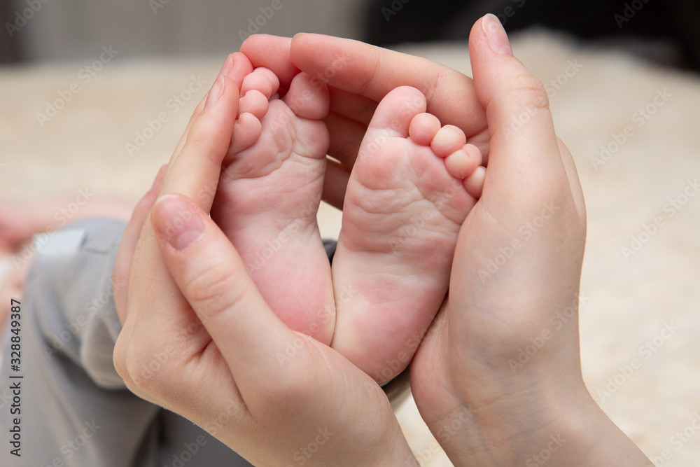 Baby feet in mother hands. Tiny Newborn Baby's feet on female Shaped hands closeup. Mom and her Child. Happy Family concept. Beautiful conceptual image of Maternity Baby feet in mother hands. Tiny Newborn Baby's feet on female Shaped hands closeup. Mom and her Child. Happy Family concept. Beautiful conceptual image of Maternity