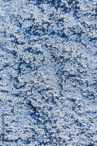Texture of ice on the frozen lake. Blue color background.