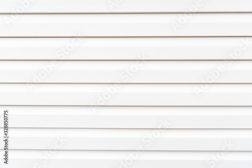 White construction vinyl siding panels. House covered with plastic vinyl siding. Vinyl siding wall surface with horizontal lines