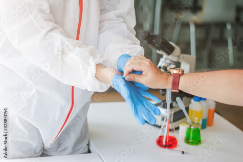 Medical scientists are wearing coronavirus protective clothing and rubber gloves before entering the lab for examination of coronavirus covid-19 and research for a vaccine against coronavirus covid19