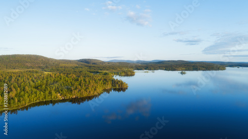Aerial panoramic landscape view of a beautiful bay on the Great Lakes, Lake Inari, during a vibrant sunset. Lapland.