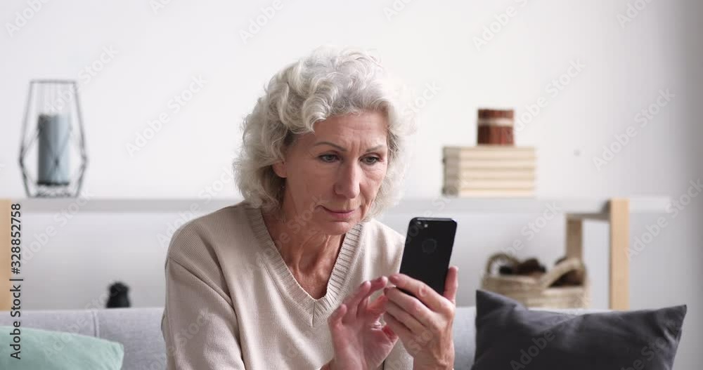 Amazed senior lady celebrating mobile win concept. Overjoyed 70 years old woman using smartphone reads good news in sms. Happy lucky elder female customer feels excited gets shopping sale offer Amazed senior lady celebrating mobile win concept. Overjoyed 70 years old woman using smartphone reads good news in sms. Happy lucky elder female customer feels excited gets shopping sale offer