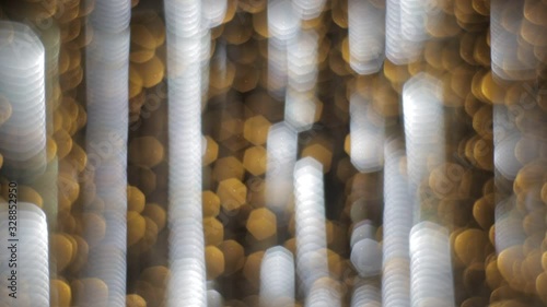 Colorful running bokeh lights in the New Year or Christmas fountain yellow and white night illumination