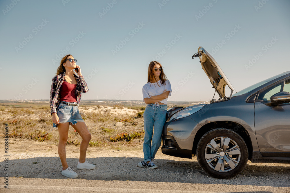 Girls with a broken a car on country road
