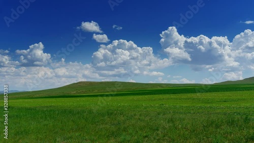 Green hill with grass under cloudy sky, timelapse 4k