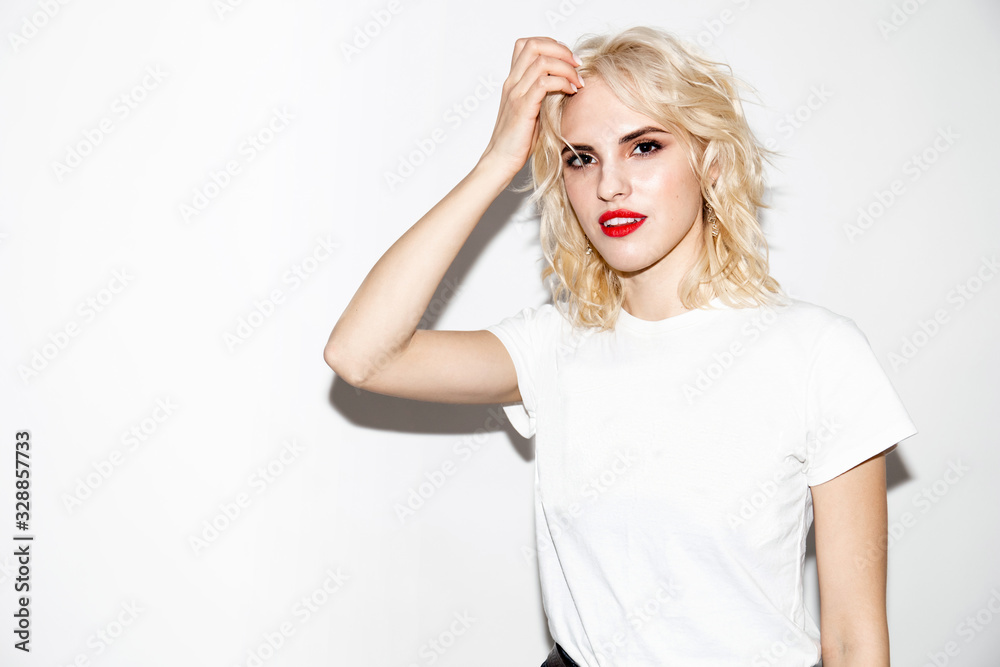 young beautiful blonde girl with a cute face in a white t-shirt on a white background, studio fashion photo with copy space young beautiful blonde girl with a cute face in a white t-shirt on a white background, studio fashion photo with copy space