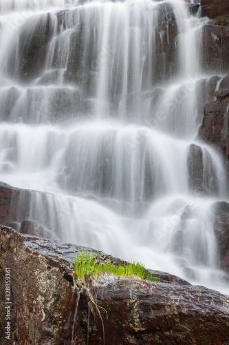 Cascades of powerful Monk s jump waterfall  the tallest in Serbia  streaming down the wet  red cliff rocks during early spring