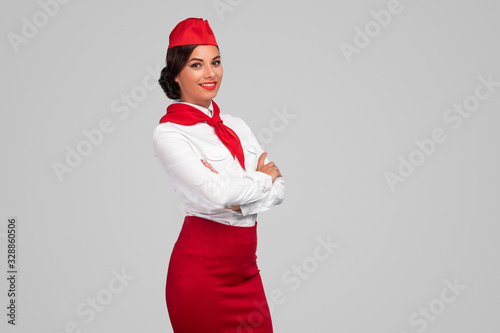 Confident adult air hostess in colorful uniform