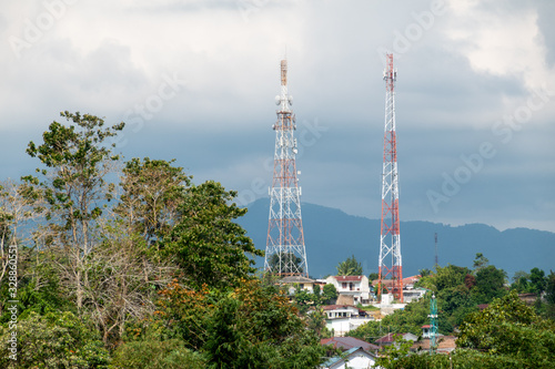 Radio Towers Surrounded By Trees Under a Stormy Sky