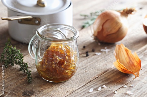 Homemade onion marmelade (jam) in glass jar on  rustic wooden table.Selective focus. photo