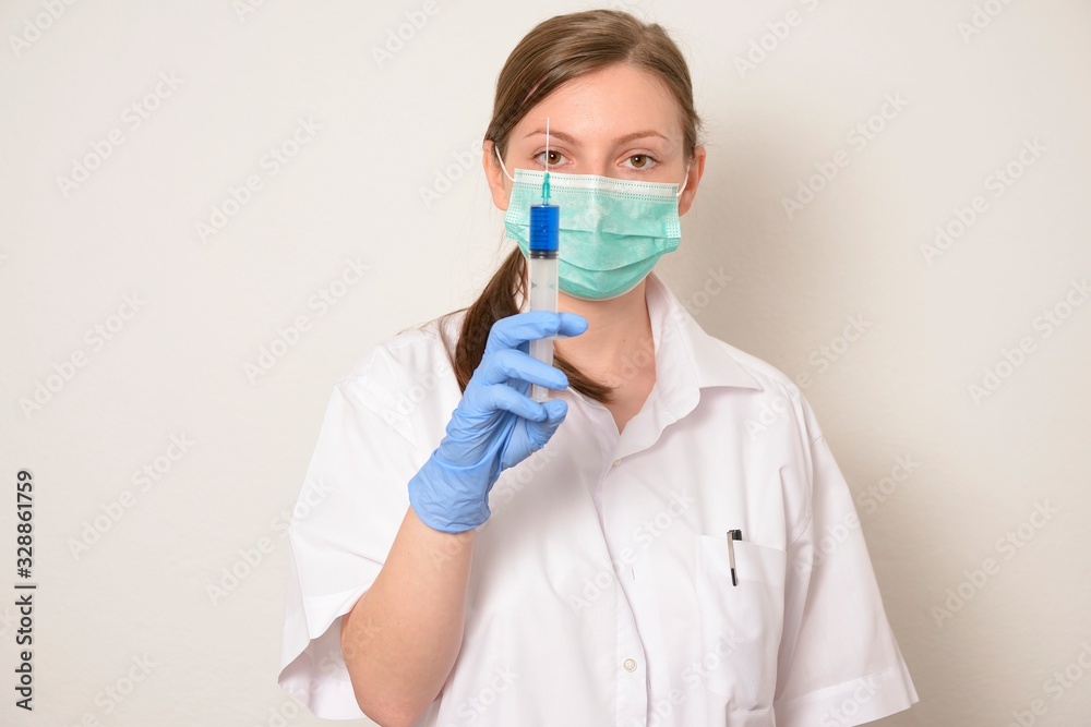 Female doctor in protection mask, and glove holds syringe with vaccine. Dramatic emotion. Concept of virus protection.