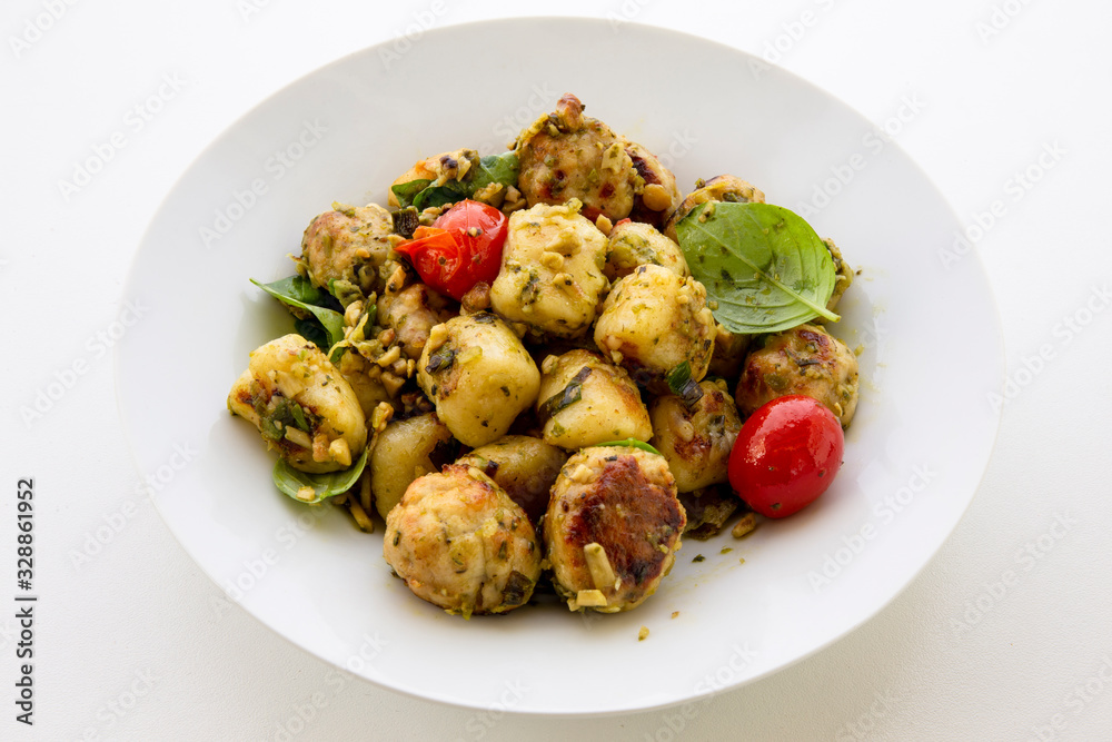 Gnocchi and chicken meatballs with pesto sauce, basil, tomatoes and nuts Gnocchi and chicken meatballs with pesto sauce, basil, tomatoes and nuts