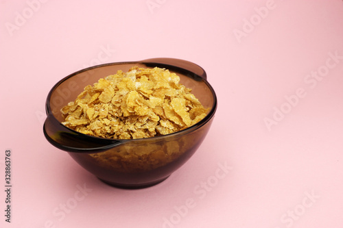 Cornflakes in a glass plate on a pink background photo