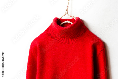 白バックとハンガーにかけた赤いタートルセーターの肩や襟のクローズアップ © minianne