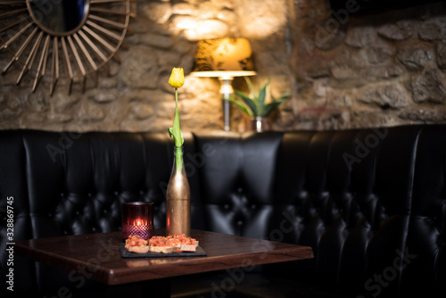 Fototapeta Naklejka Na Ścianę i Meble -  Table and seats  setup for romantic couple in a city Wine Bar