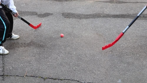 children are playing hockey on the street