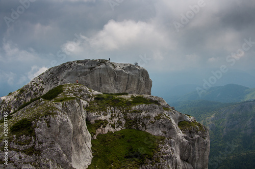 Hikers on a cliff in Retezat National park in Carpathian mountain range, Romania. Enjoying nature photo
