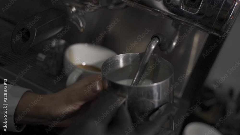 Making milk for a cappuccino using a coffee machine. Making milk for a cappuccino using a coffee machine.