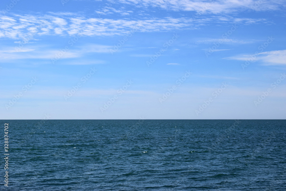 Beautiful view of the calm sea. Blue water surface with small waves in calm. View of the endless sea. Horizon in the sea.