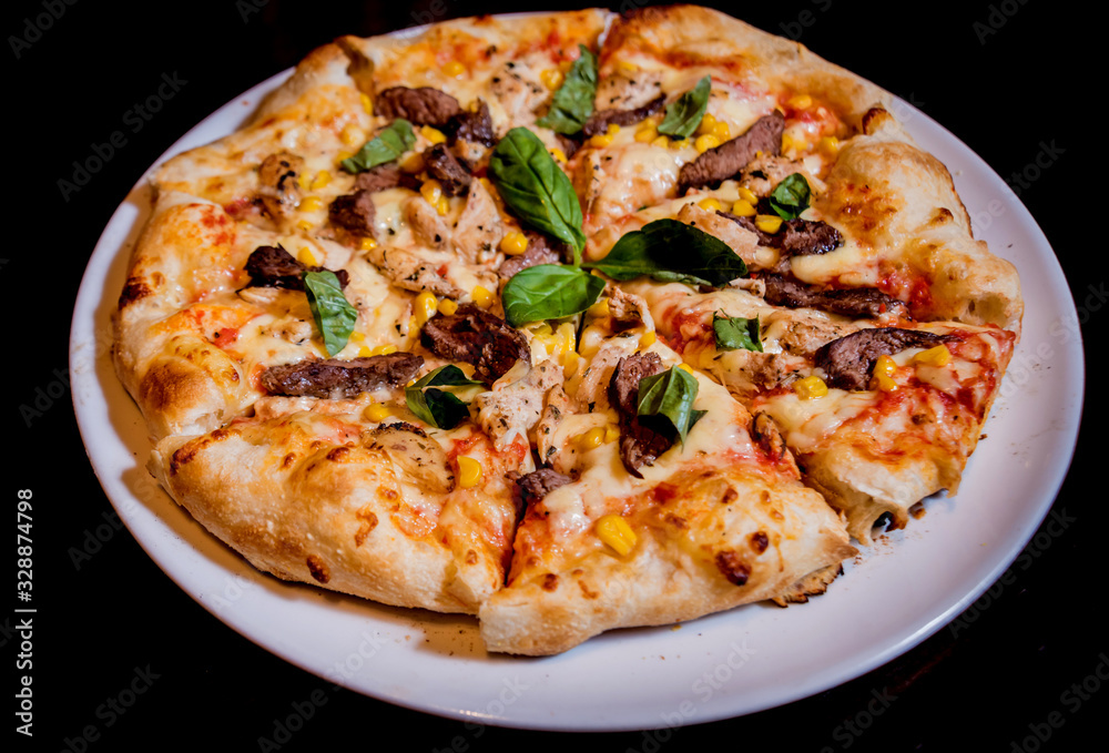 Tasty pizza with chicken and vegetables. Restaurant.