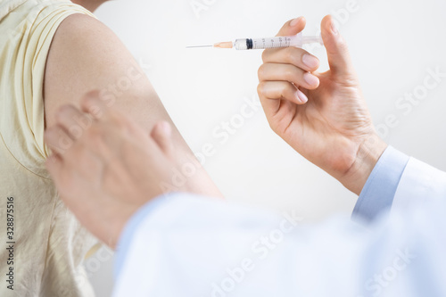 Asian man get coronavirus, flu and measles vaccine shot, vaccination in hospital for good heath, medicine injection vial dose for treatment patient