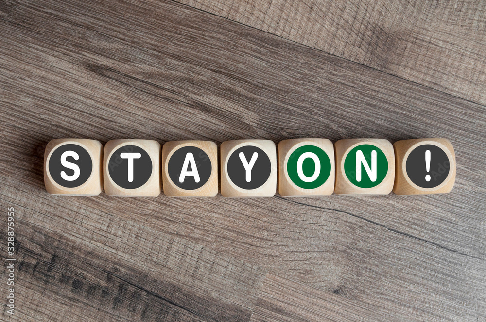 Fototapeta premium Cubes and dice on wooden background with message stay on