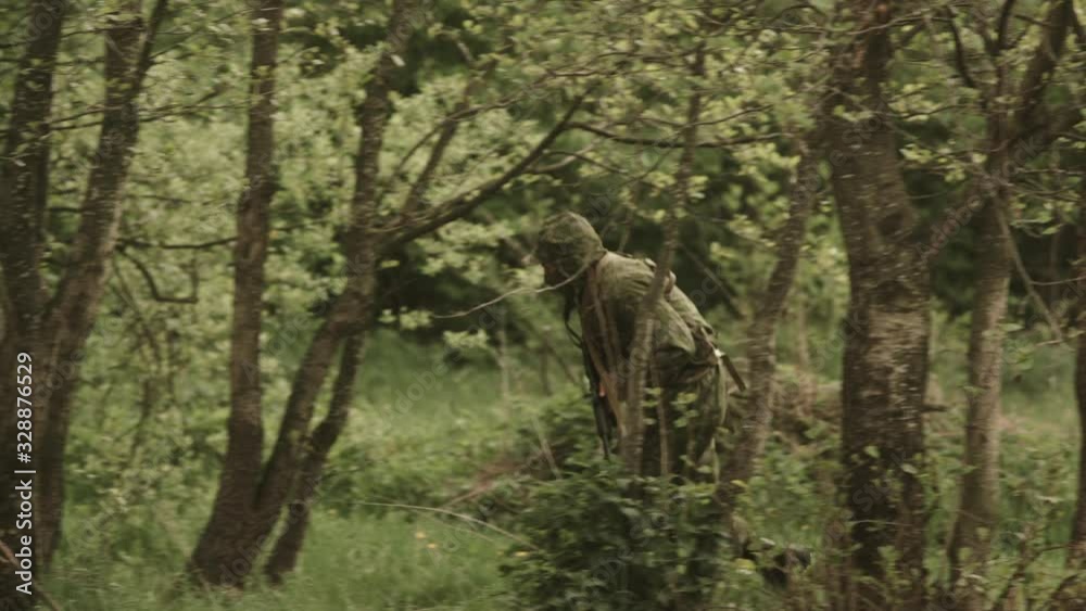Soldiers With Arms In Hands In Forest. Some Lie In The Grass. One Soldier Runs Between The Trees. Soldiers With Arms In Hands In Forest. Some Lie In The Grass. One Soldier Runs Between The Trees.
