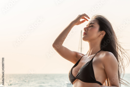 Sexy Asian Women in Black Bikini at Sunset on her Private Yacht.