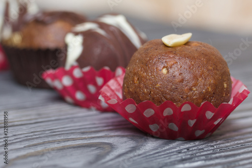 Chocolate Potato Cake. Garnished with walnut, trickles of chocolate or sprinkled. Against the background of brushed boards.