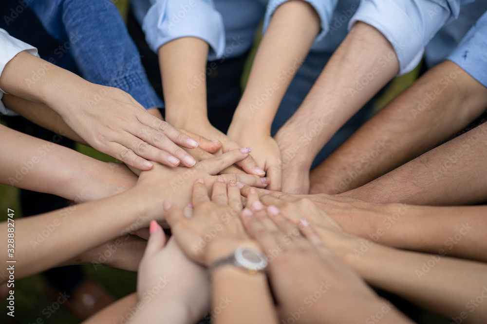 Close up to Asian people hold hand together in the middle of their group, friend with stack of hand showing the love and community of good friends. Close up to Asian people hold hand together in the middle of their group, friend with stack of hand showing the love and community of good friends.
