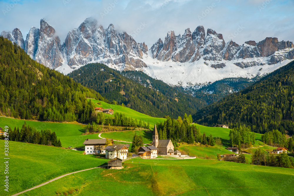 Aerial view on Santa Maddalena church and Geisler Dolomites Alps mountains with snow in the springtime