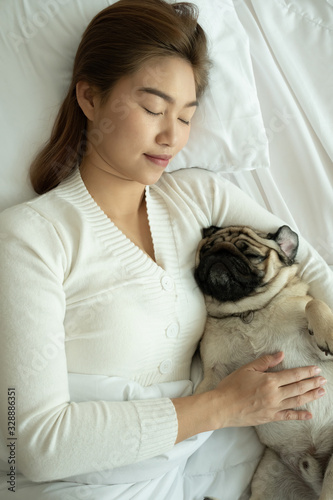 woman sleep with dog pug breed on bed in bedroom,Pet and owner Concept