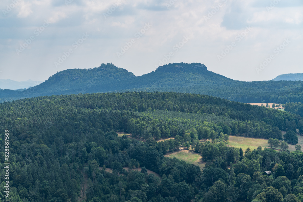 Naklejka premium Königstein fortress on the banks of the Elbe river, green landscape with mountains in the background. Dresden, Saxon Switzerland, Germany.