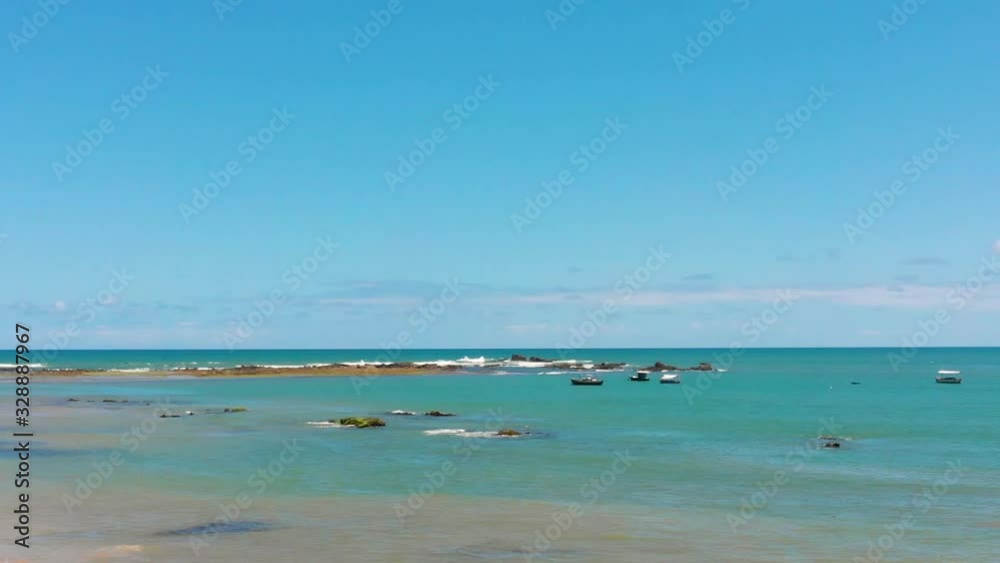 Drone pan right to left. Begining showing some fishing boats in the sea and stops at the shore. Drone pan right to left. Begining showing some fishing boats in the sea and stops at the shore.