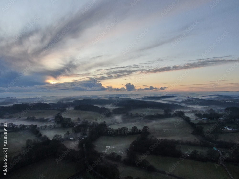 An aerial view of fields and the hedges on a misty evening