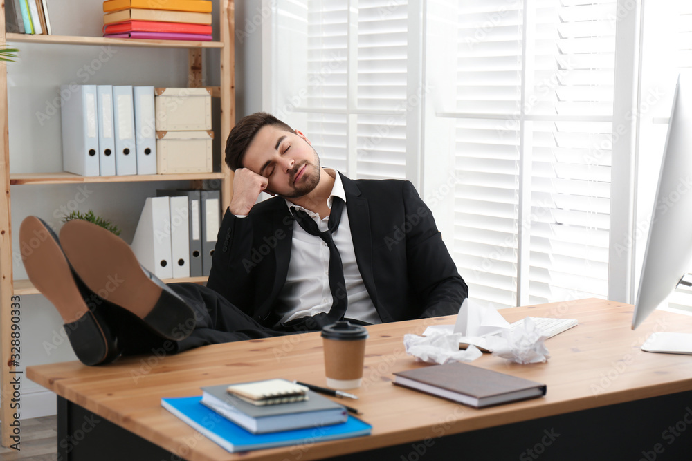 Lazy employee sleeping at table in office Lazy employee sleeping at table in office