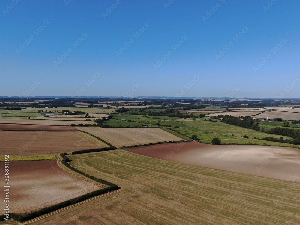 an aerial view of rolling ploughed farmland in the summer an aerial view of rolling ploughed farmland in the summer